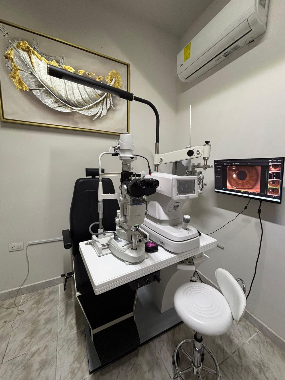 Consultorio de oftalmología con lámpara de hendidura, autorrefractómetro y monitor